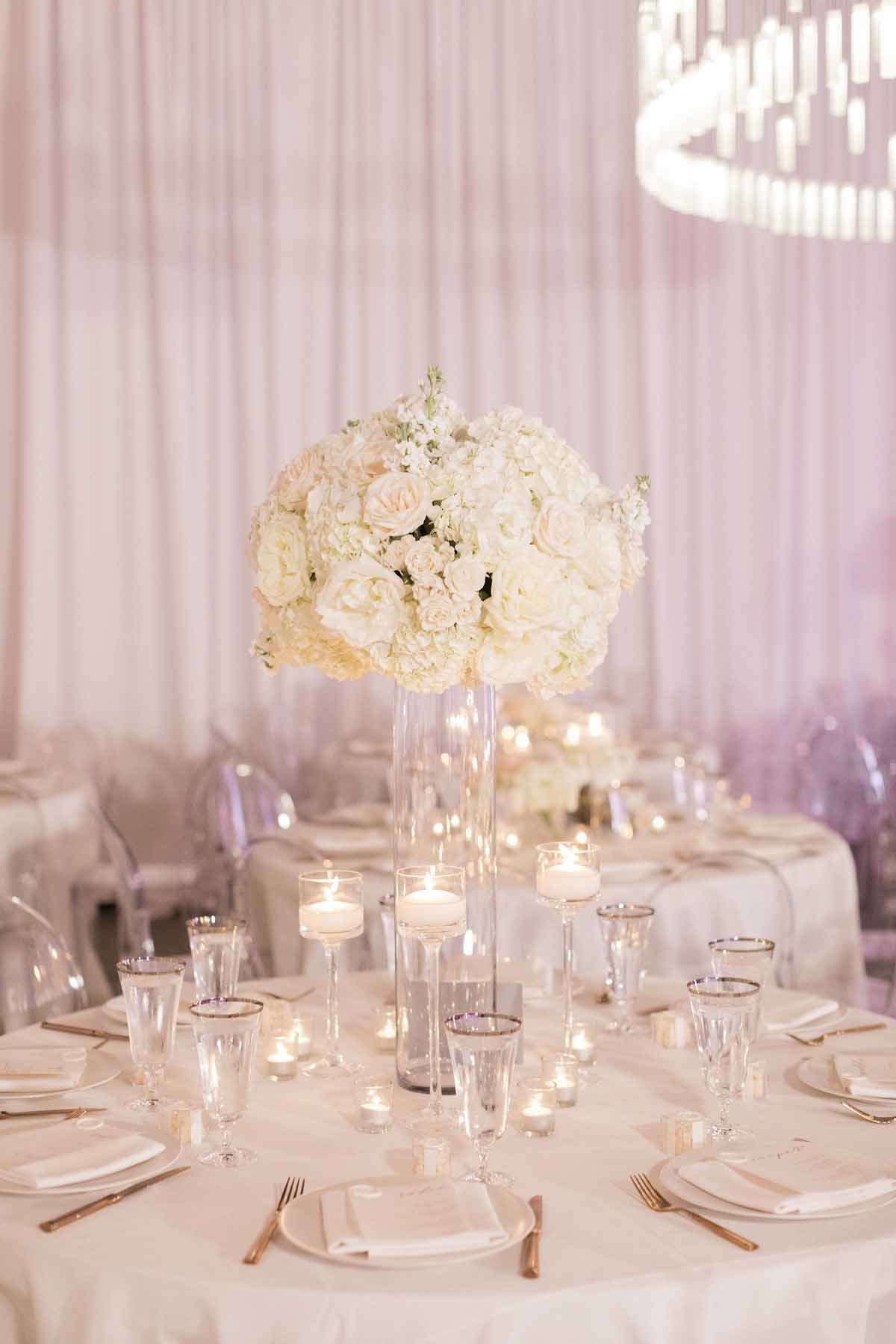 Elevated arrangement of all white roses and hydrangea seem to float in this all white space