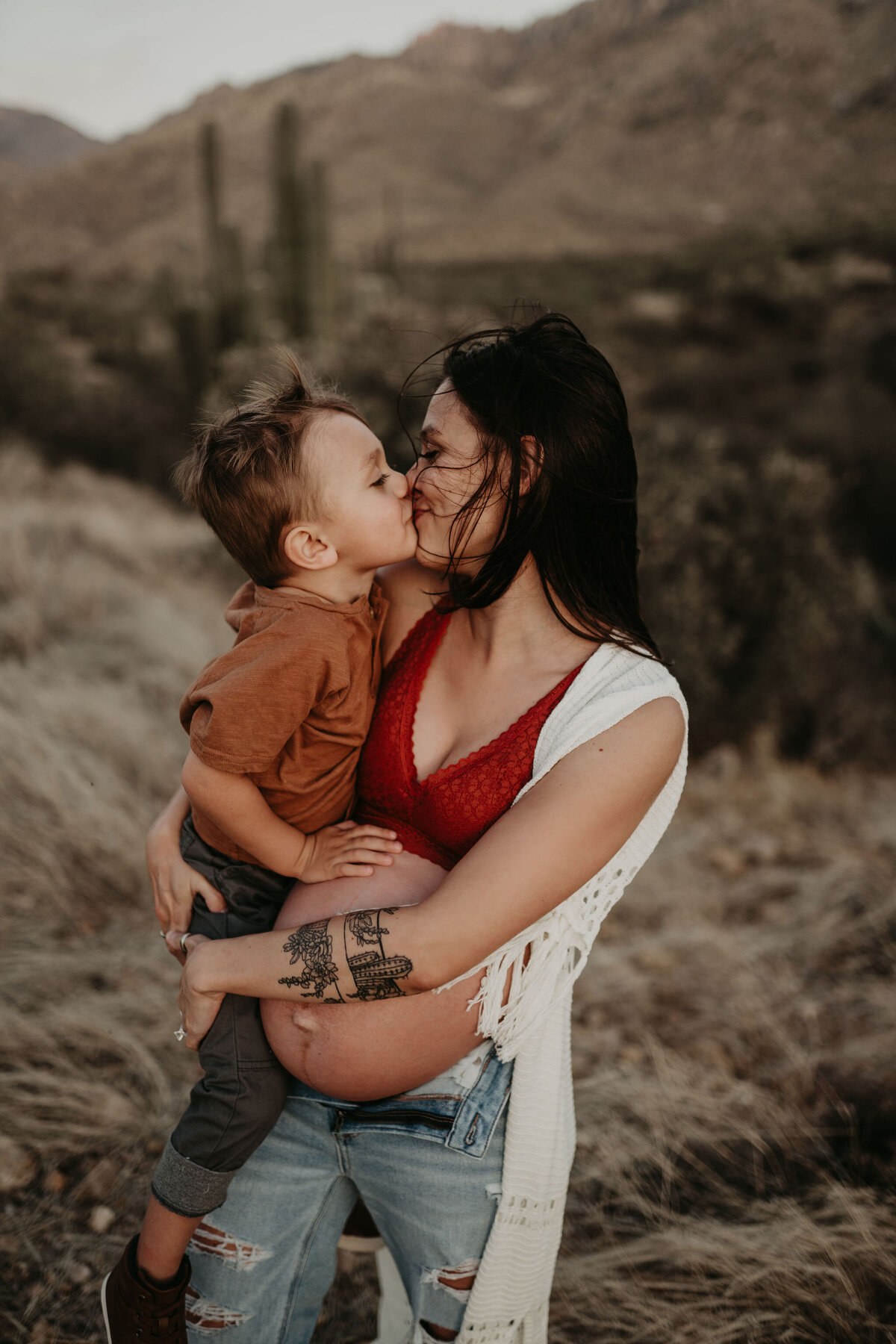 tattooed mom and son kiss in the desert