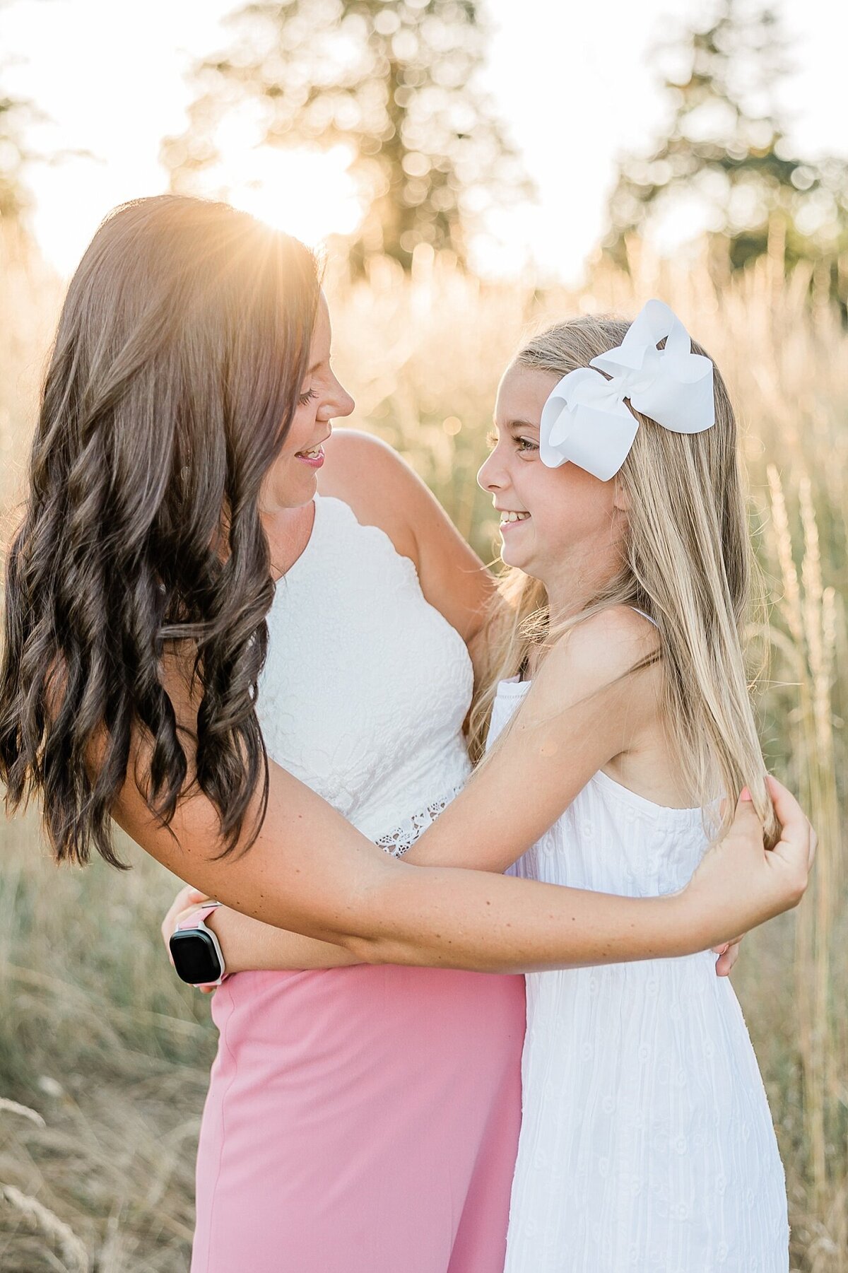 Mom and daughter hugging at sunset