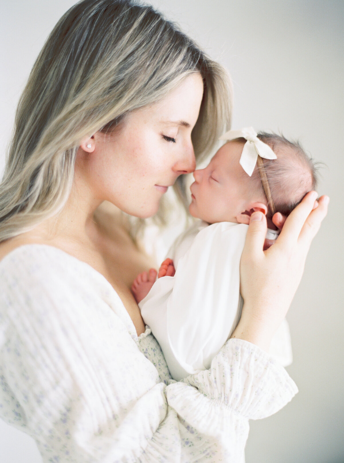 new mother in floral dress holding new baby photographer milwaukee wi  Talia Laird Photography