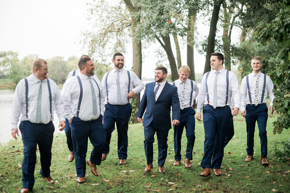 A wedding groom being surrounded by his groomsmen