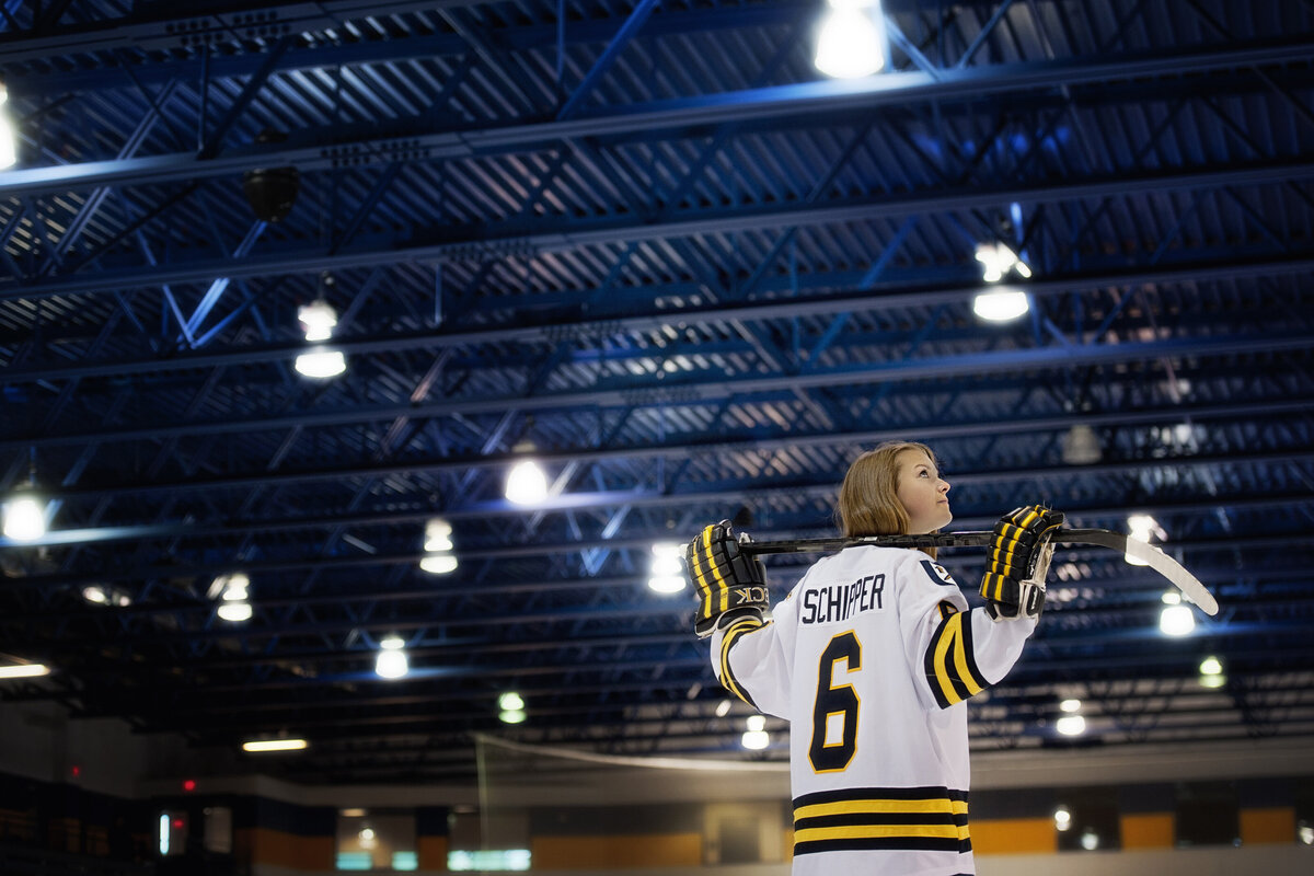 senior photo of female hockey player in a ice arena