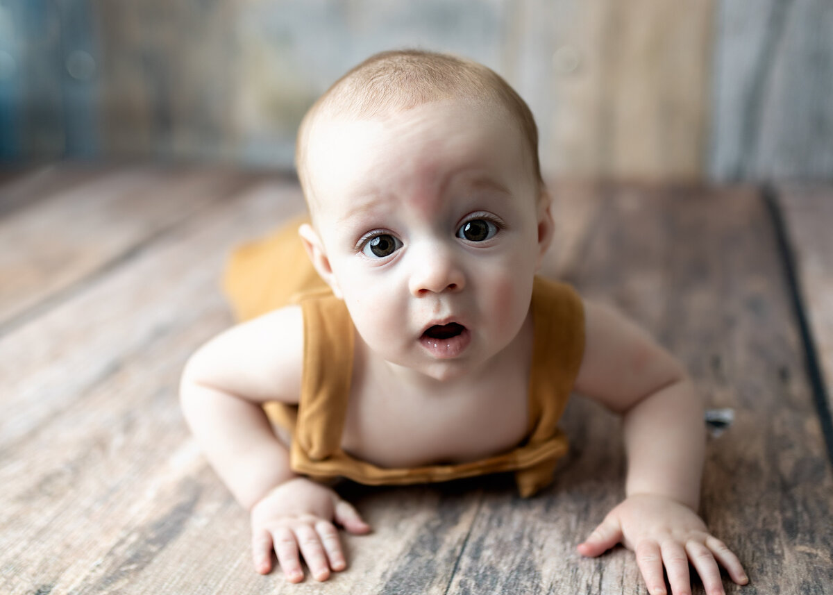 baby boy crawls for photographer Erin JAchimiak during a sitter photography session in Denver Studio