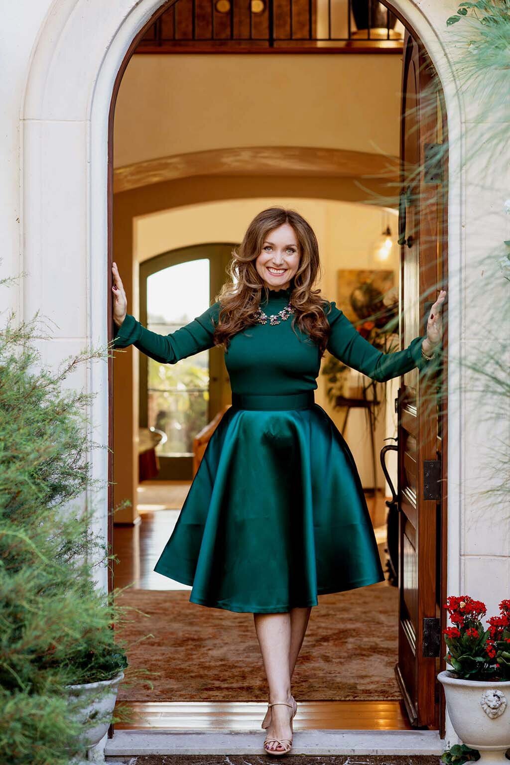 Gabriella Taylor standing in an open doorway in a green dress