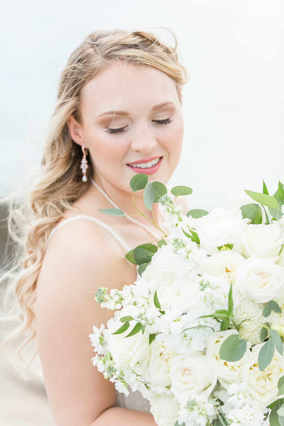 Bridal portrait. Bride's head turned over her shoulder with her eyes closed and the wind in her hair. Captured by best New England wedding photographer Lia Rose Weddings.