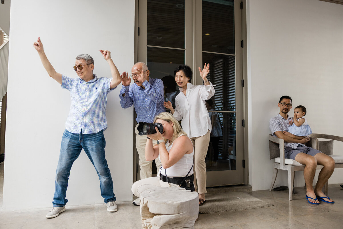 People with their hands up as a photographer is knelt in front of them