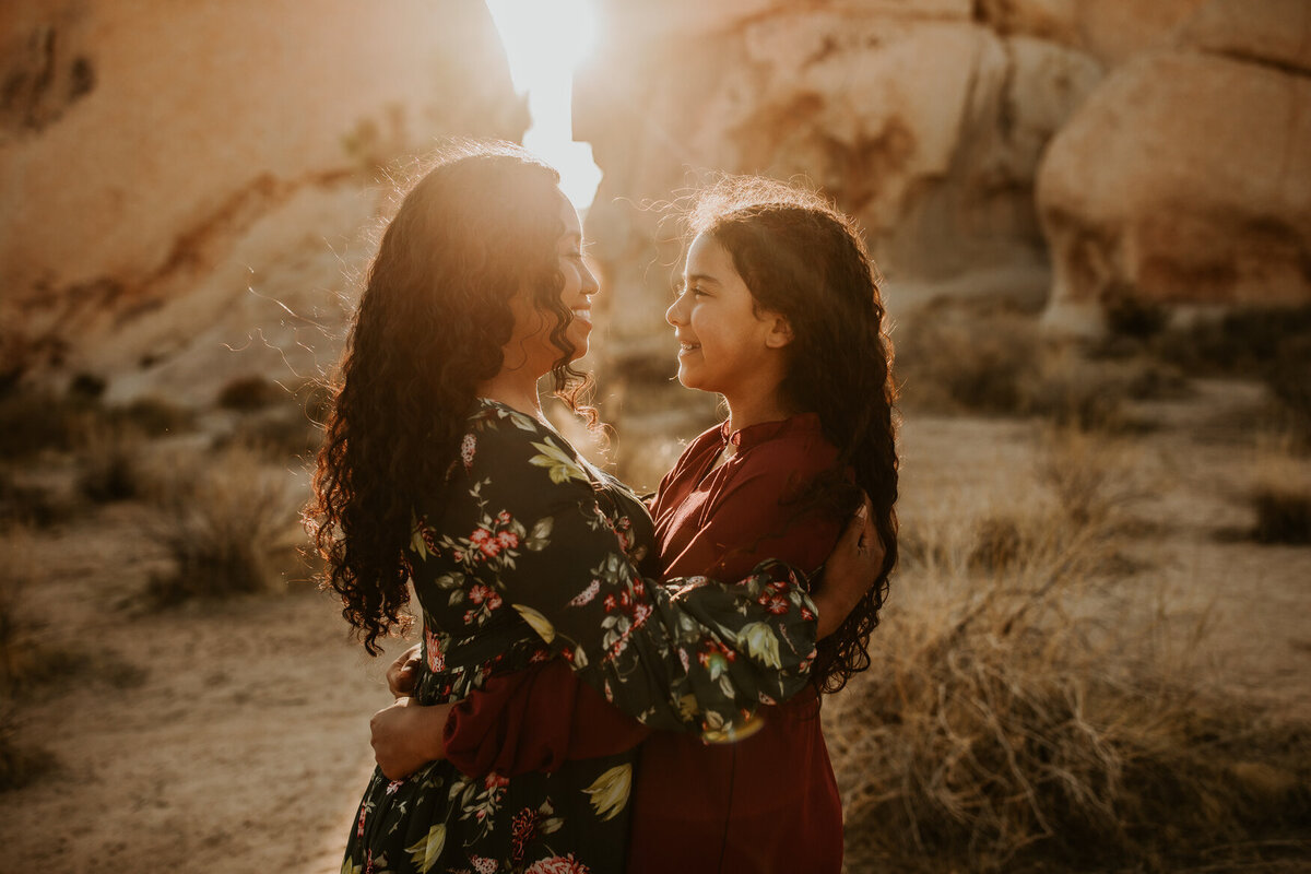 Mother and daughter embrace and look at one another at Joshua Tree National Park
