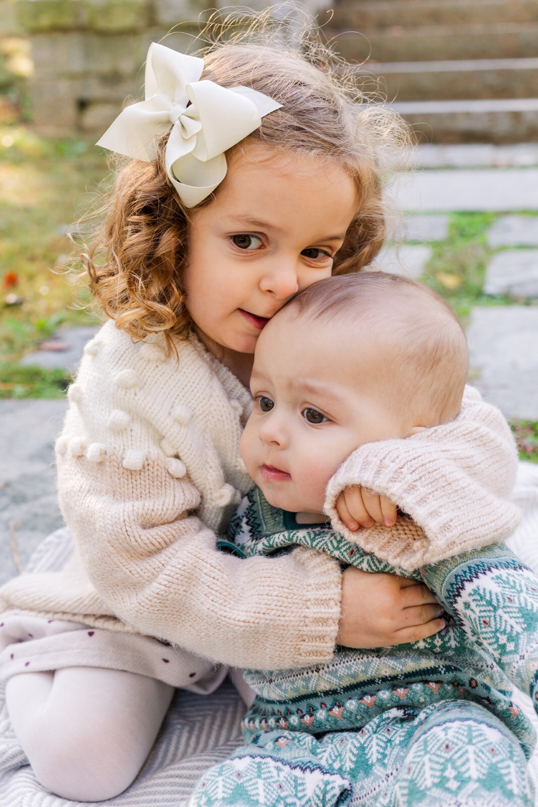 Siblings, Toddler sister hugging baby brother sitting on a park path in Atlanta by Laure Photography