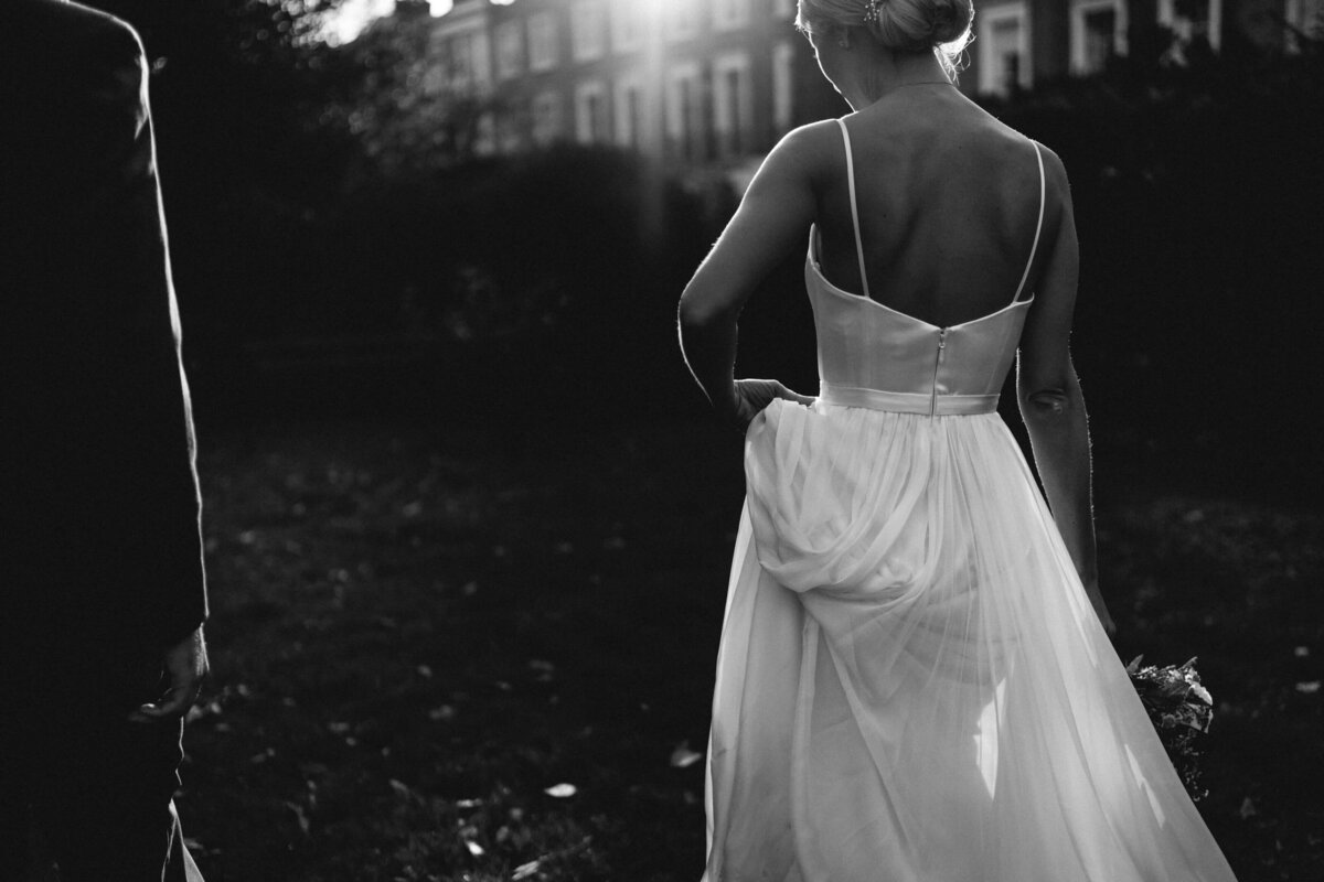 A black and white photo of a bride walking