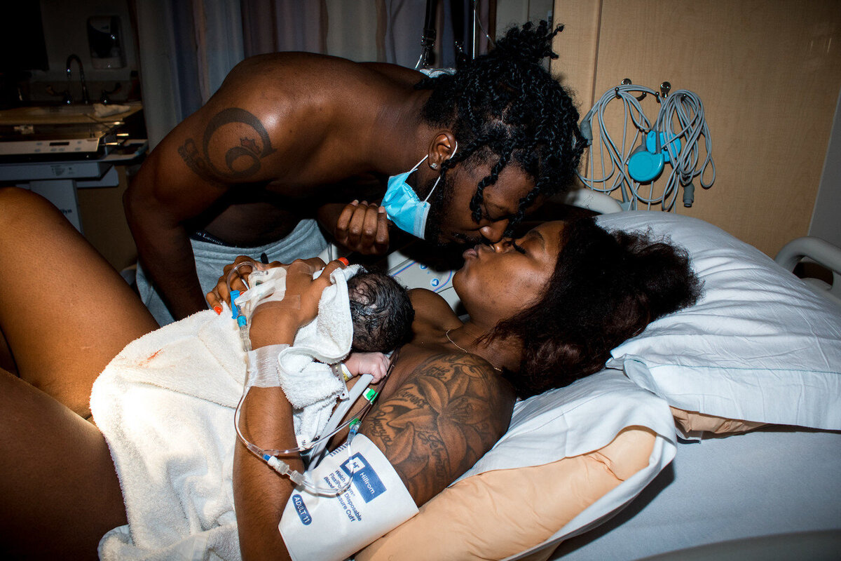 Couple kissing after birthing newborn baby