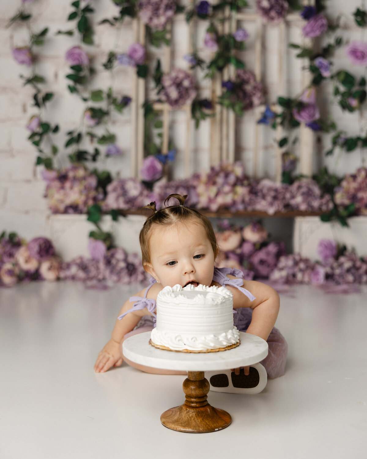 Whimsical purple blooms, tiny fingers, and a whole lot of frosting joy! This little one's cake smash session was pure sweetness. Captured by Yucaipa cake smash photographer Kaitlyn Dawn Photography.