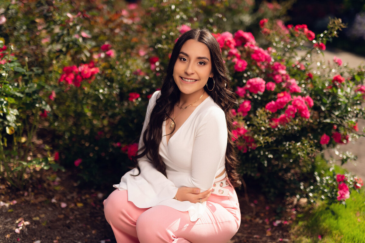 A student from Pewaukee High School visits Boerner Botanical Gardens in Hales Corners to have her portrait taken amongst red roses in full bloom.