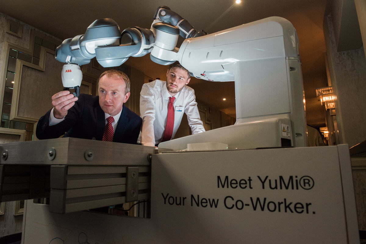 Two men using robot called Yumi