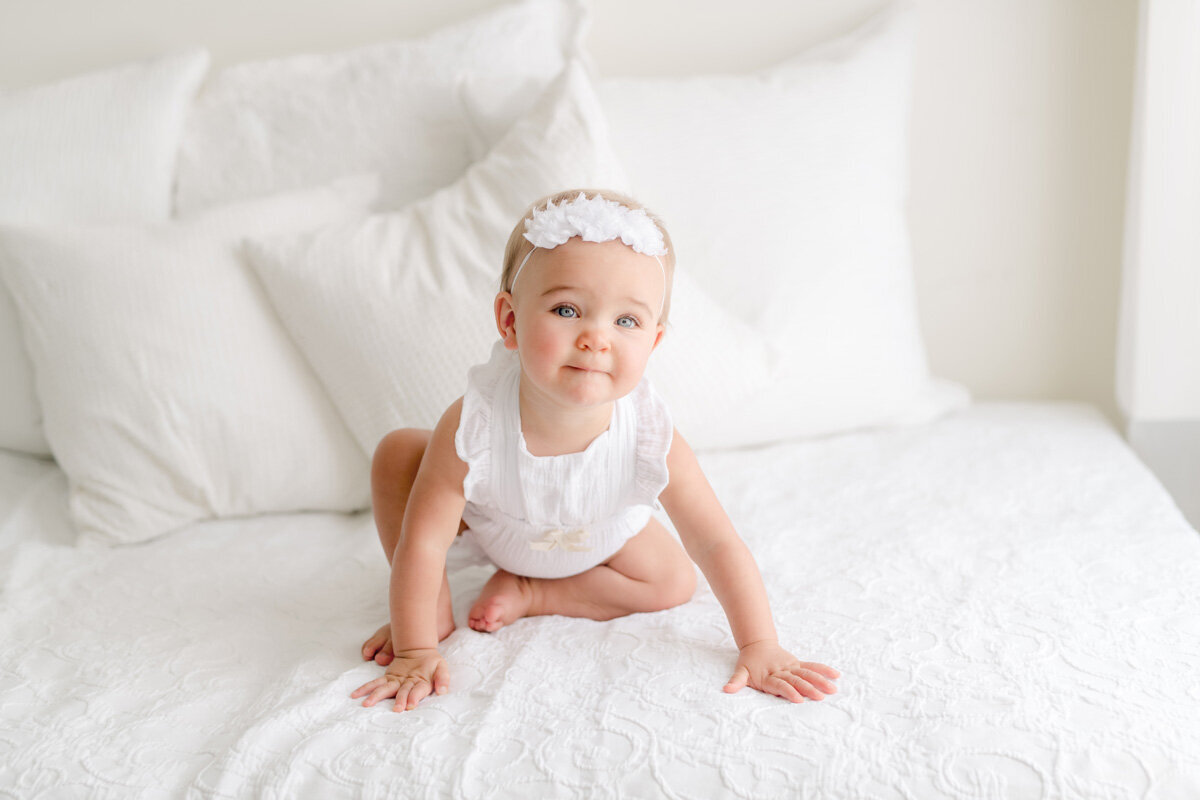 Family session of little girl sitting on a bed