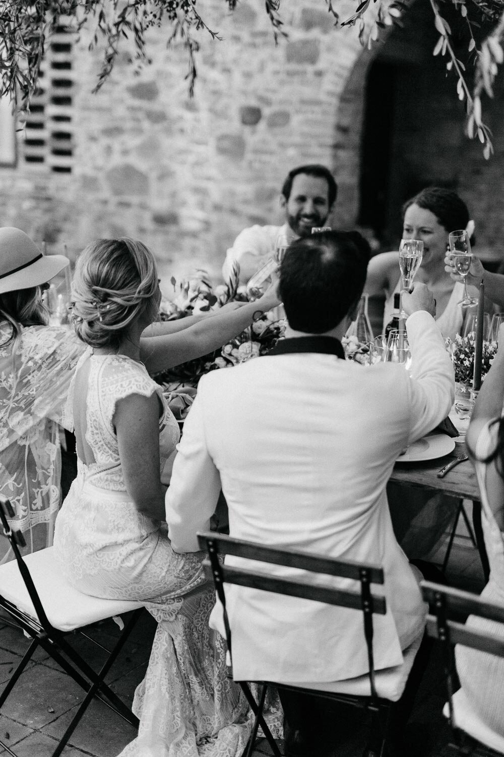 Cheers with friends during wedding reception in Tuscany