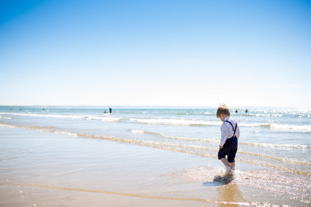 Page boy walking in the sea at Woolacombe Bay Devon