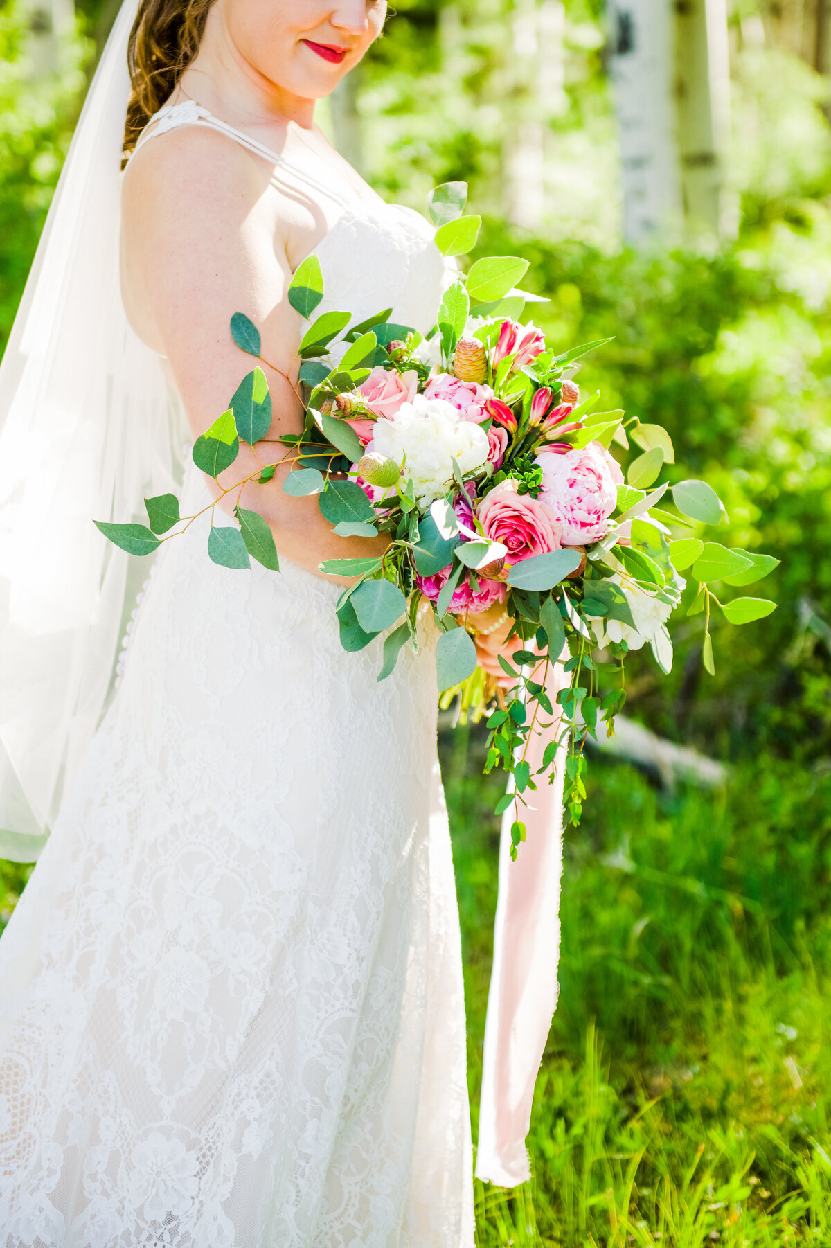 Bride holding bouquet looking down wedding aspens green summer elopement Flagstaff