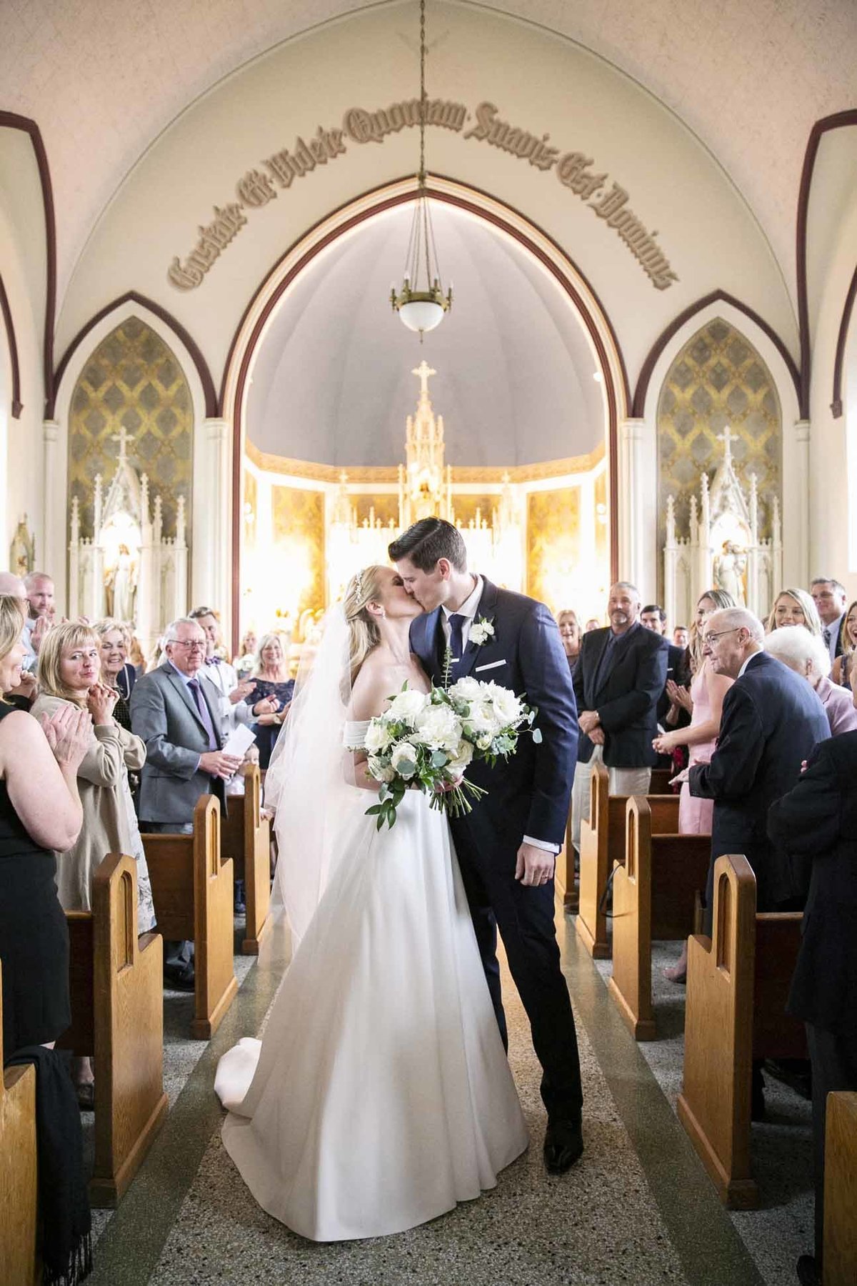 wedding couple at Villa Academy chapel with bride holding white bridal bouquet