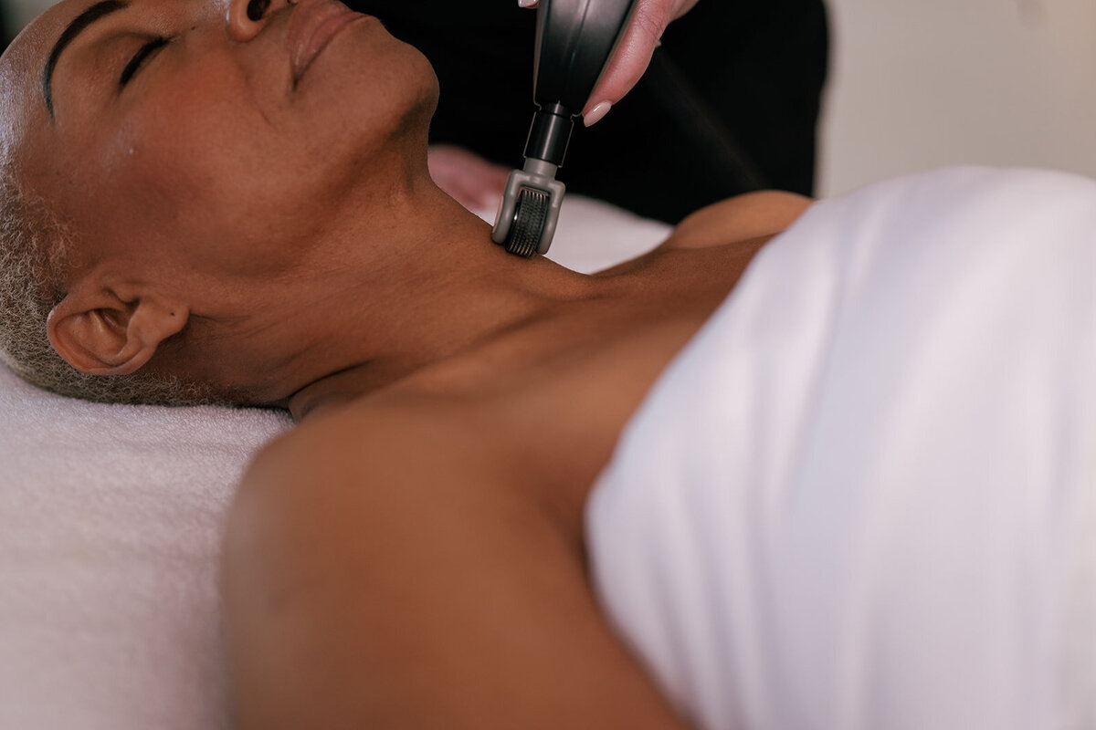Woman laying down receiving medspa treatment on her neck