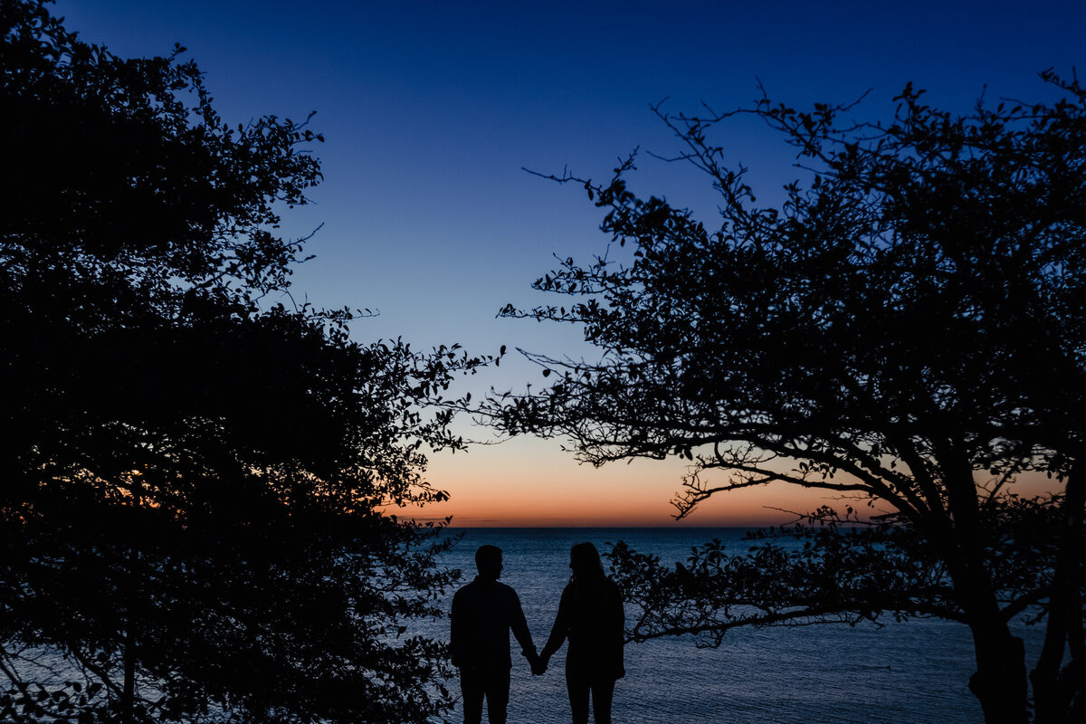 A couple is silhouetted  by the sunrise