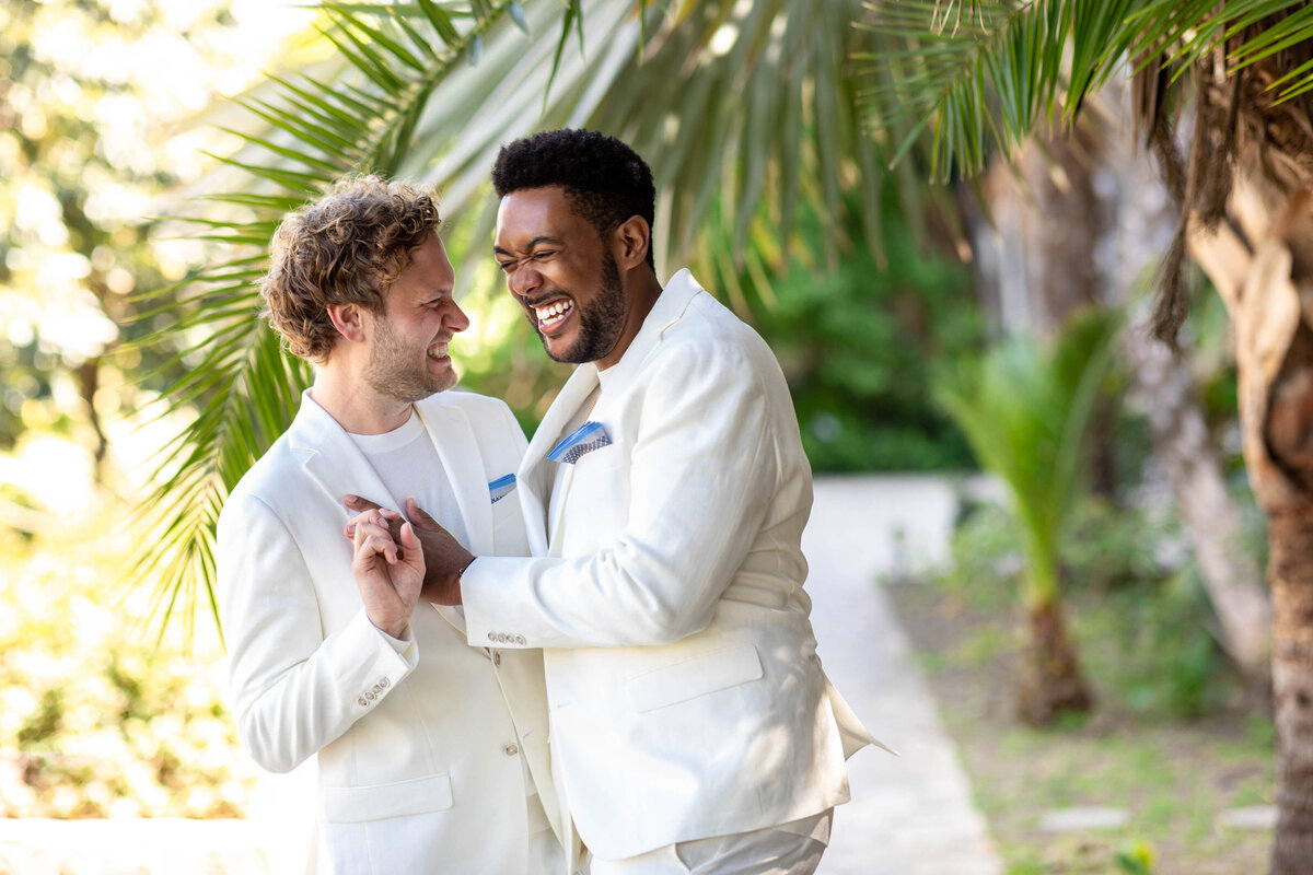 Two partners laughing and holding hands.