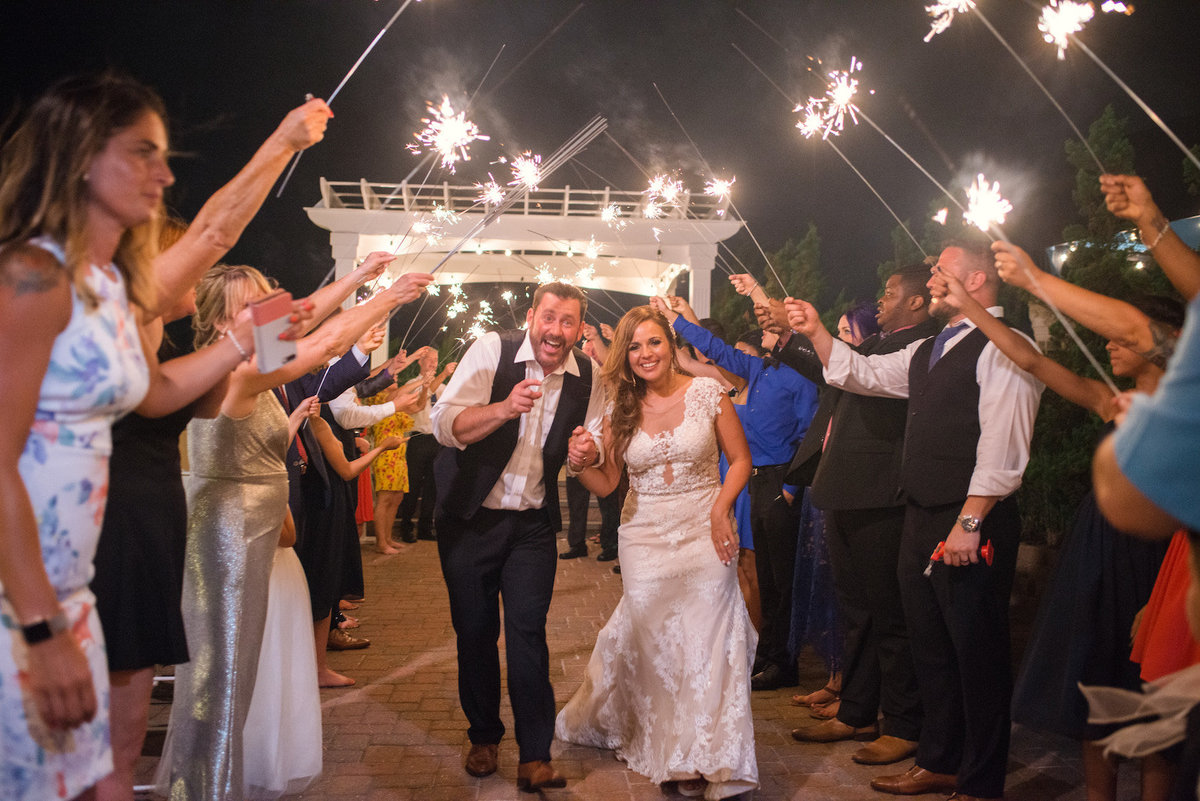 photo of bride and groom introduction with guests holding sparklers outdoors from wedding at Lombardi's on the Bay