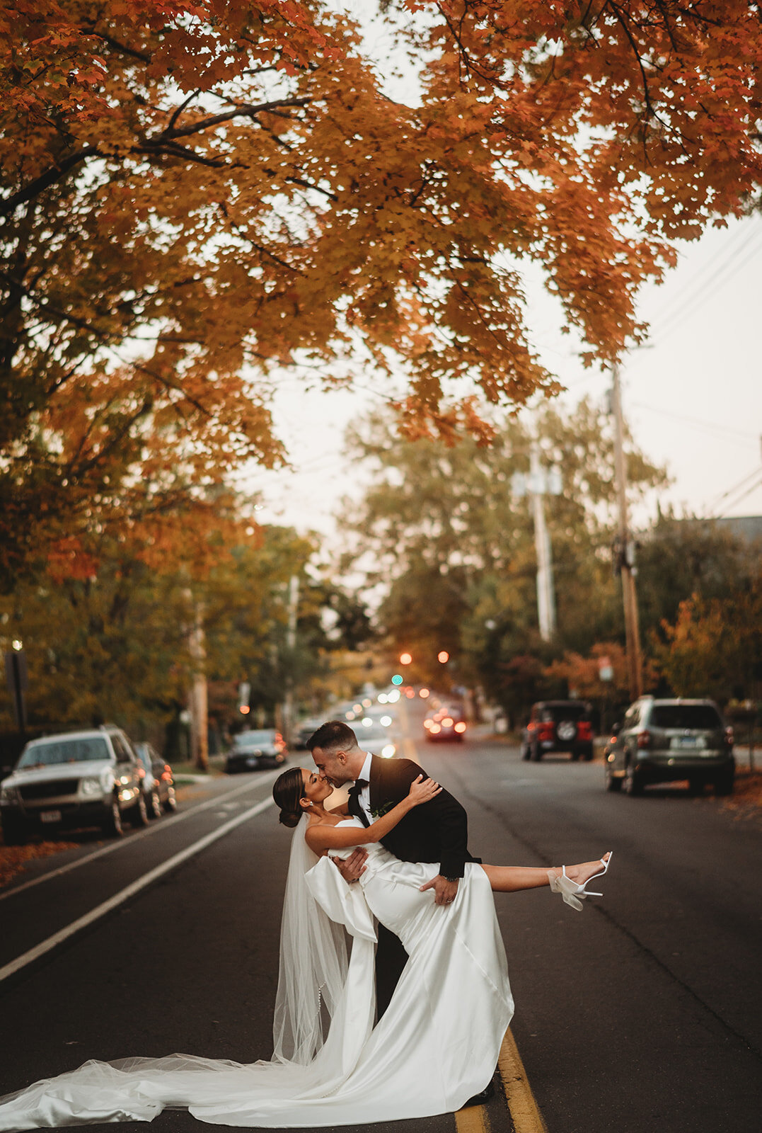 bride and groom kiss in street at new haven lawn club wedding photo by cait fletcher photography