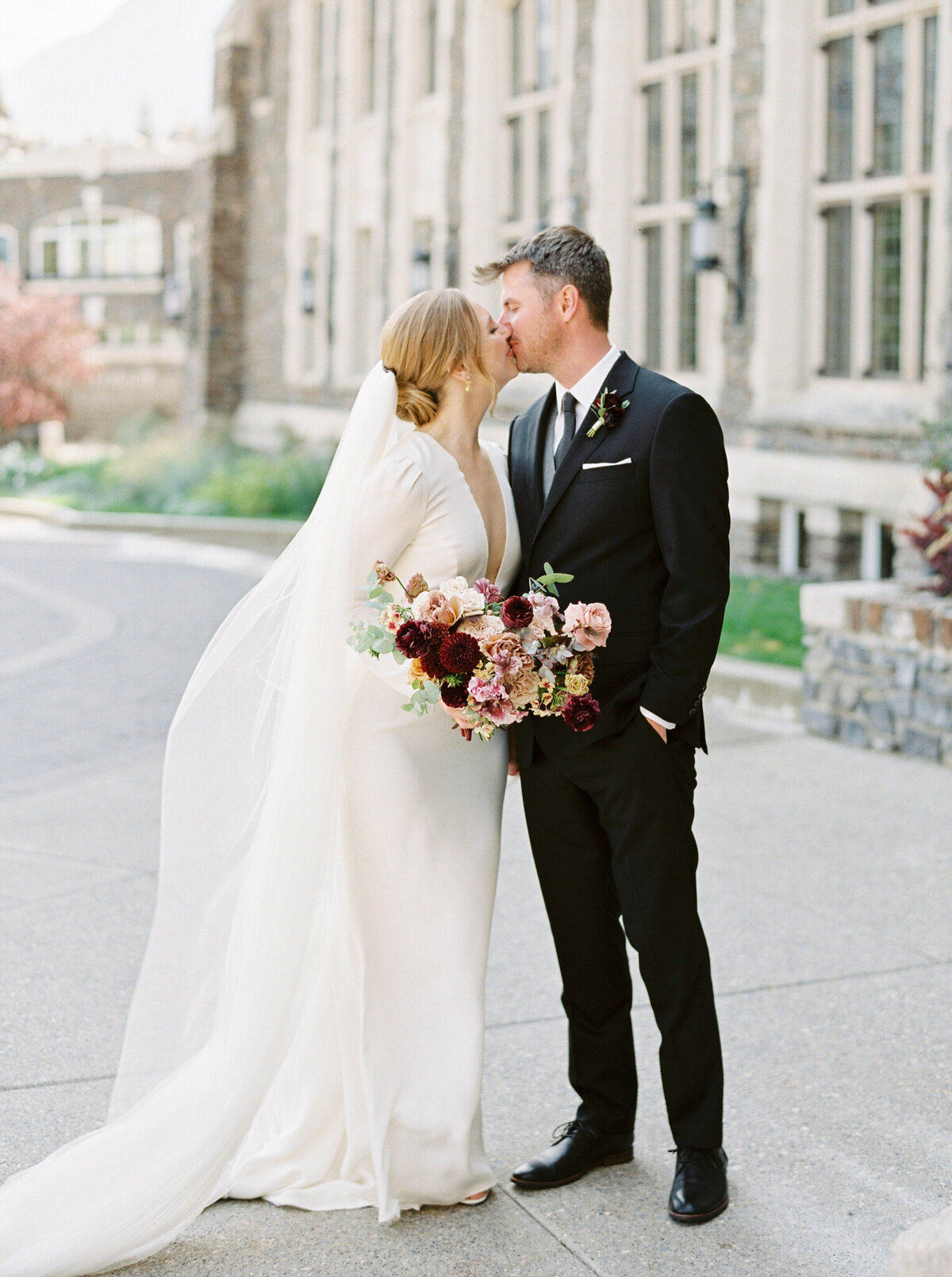 Elegant and timeless wedding inspiration, stunning couple in front of the Fairmont Banff Springs Hotel, captured by Justine Milton Photography, fine art  wedding photographer & videographer in Calgary Alberta. Featured on the Bronte Bride Vendor Guide.