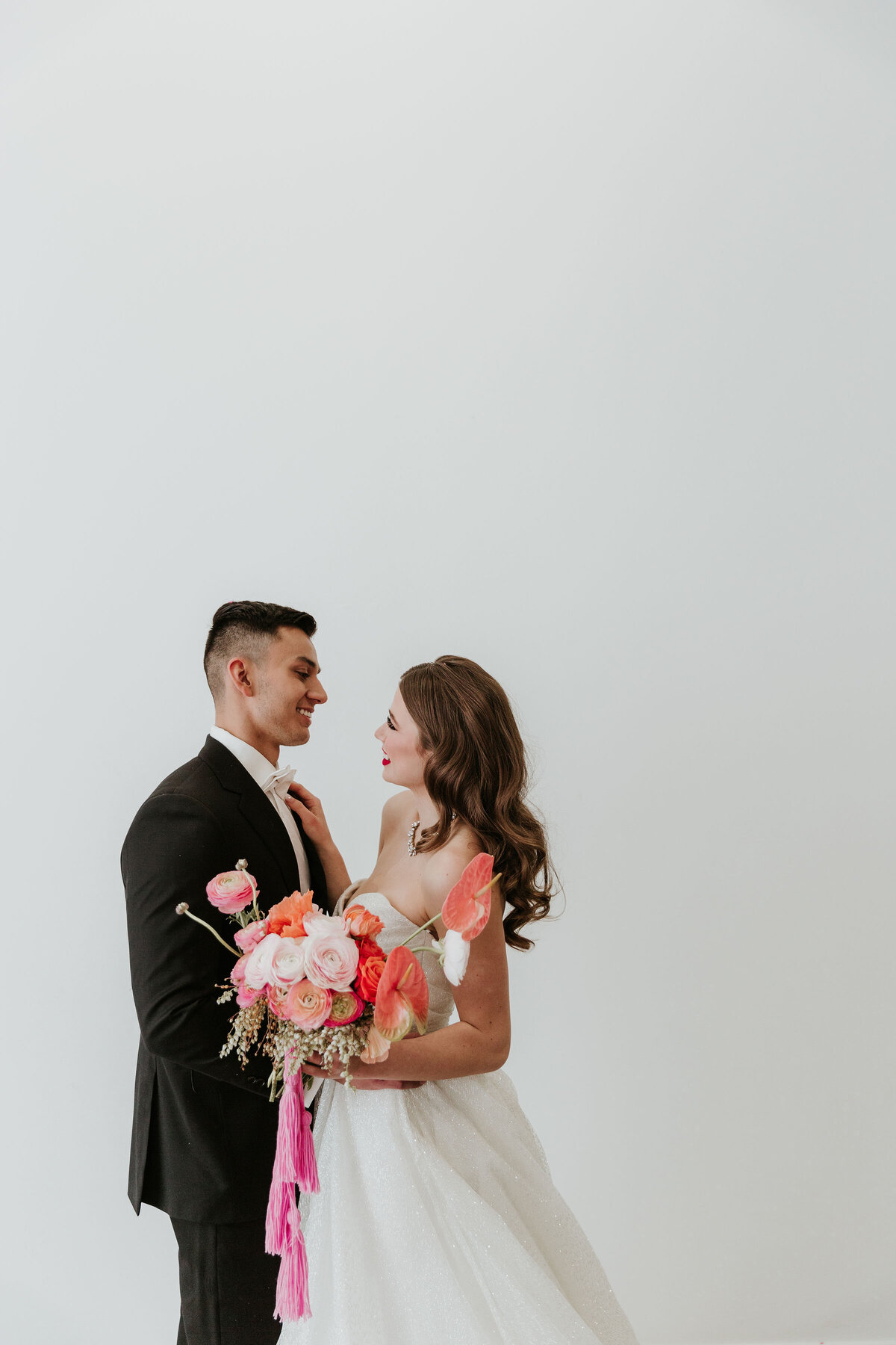 Contemporary bride holding colourful pink bouquet, wearing gown from Cameo & Cufflinks, a contemporary bridal boutique based in Calgary, Alberta. Featured on the Brontë Bride Vendor Guide.