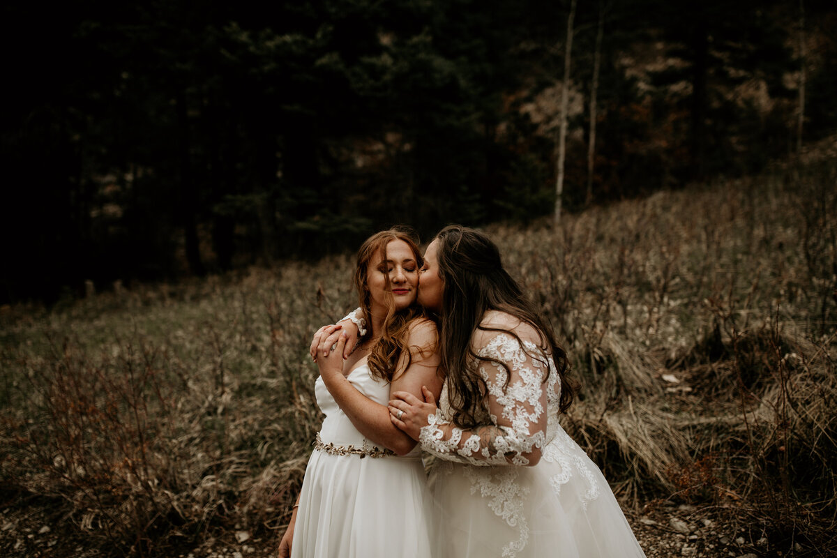 bride holding wife from behind after wedding