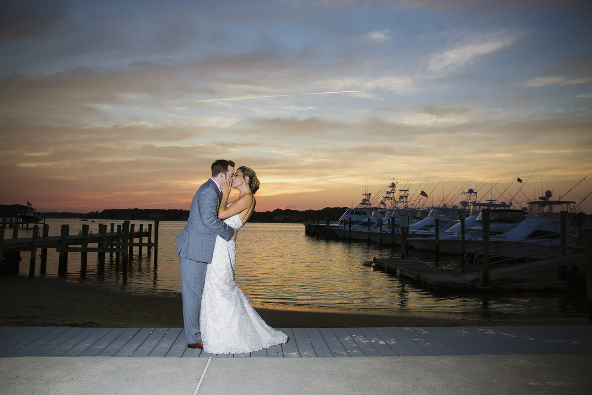 bride and groom kissing at sunset at clarks landing yacht club wedding