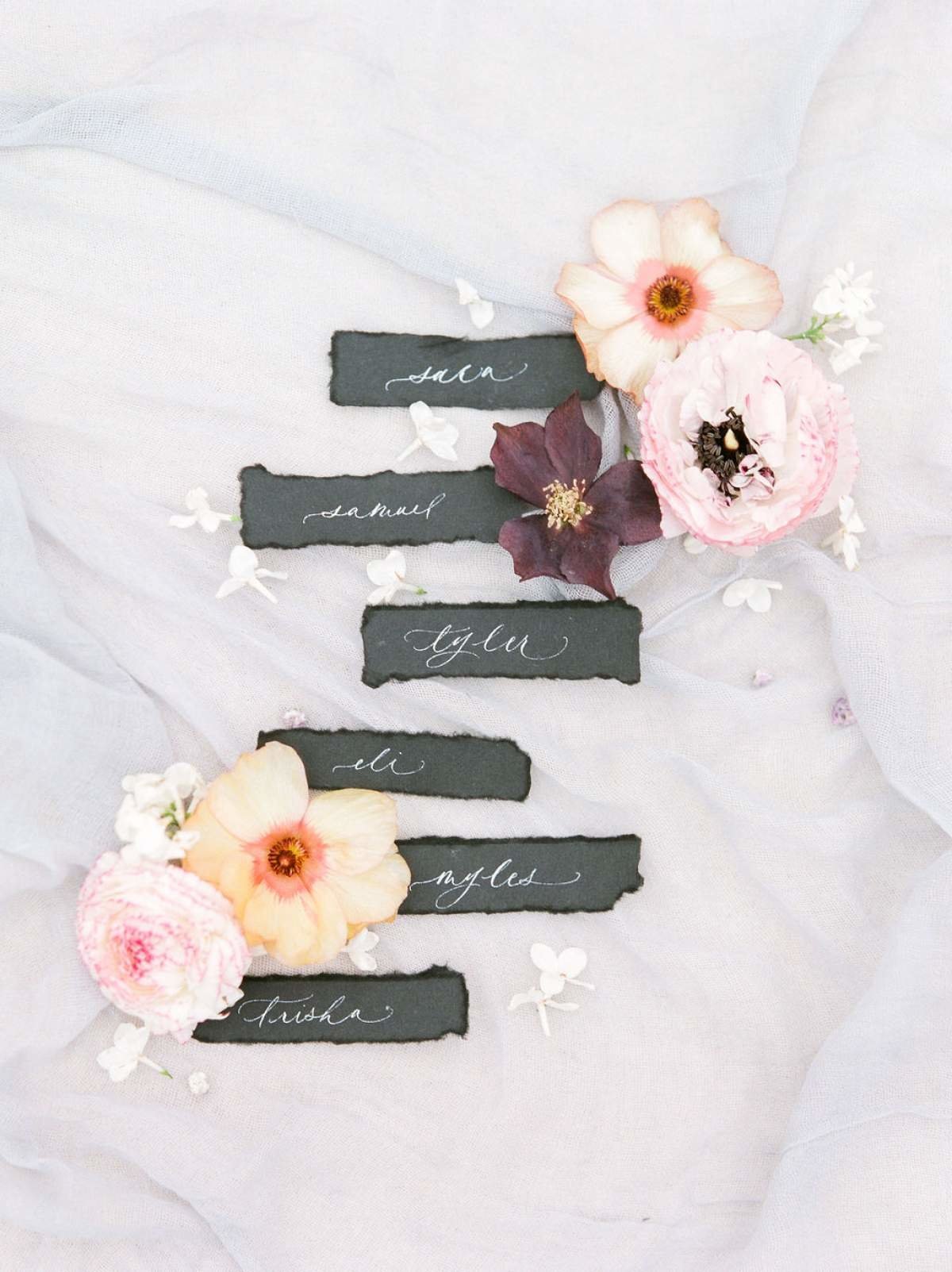 Black-Calligraphy-Escort-Cards-Flatlay-with-flowers