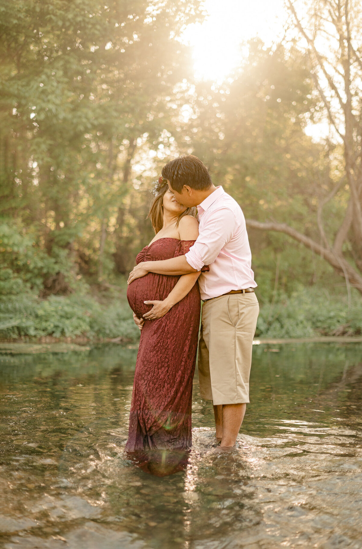 San Antonio expecting couple stands in the creek at Crescent Bend Park during golden hour maternity  pictures.