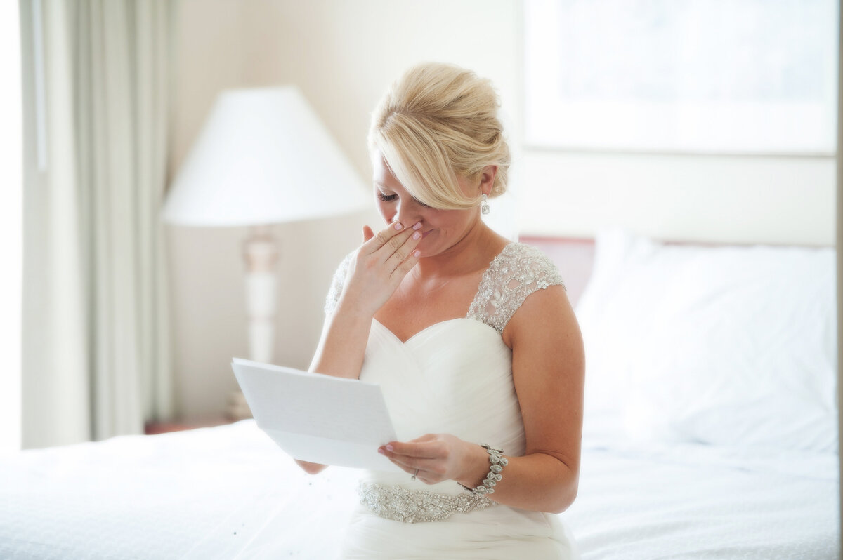 Bride reading letter from groom crying.