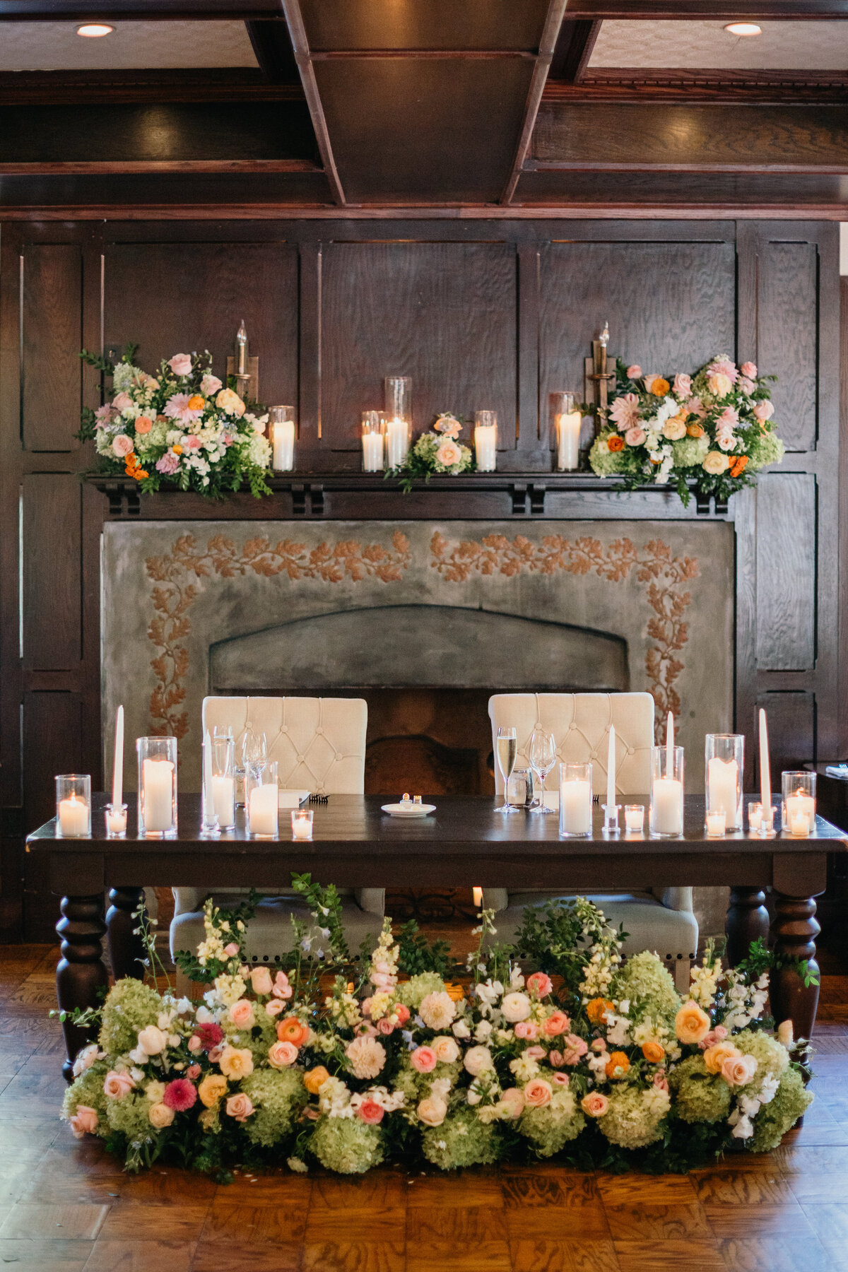 Sweetheart table with colorful floral arrangements and candles