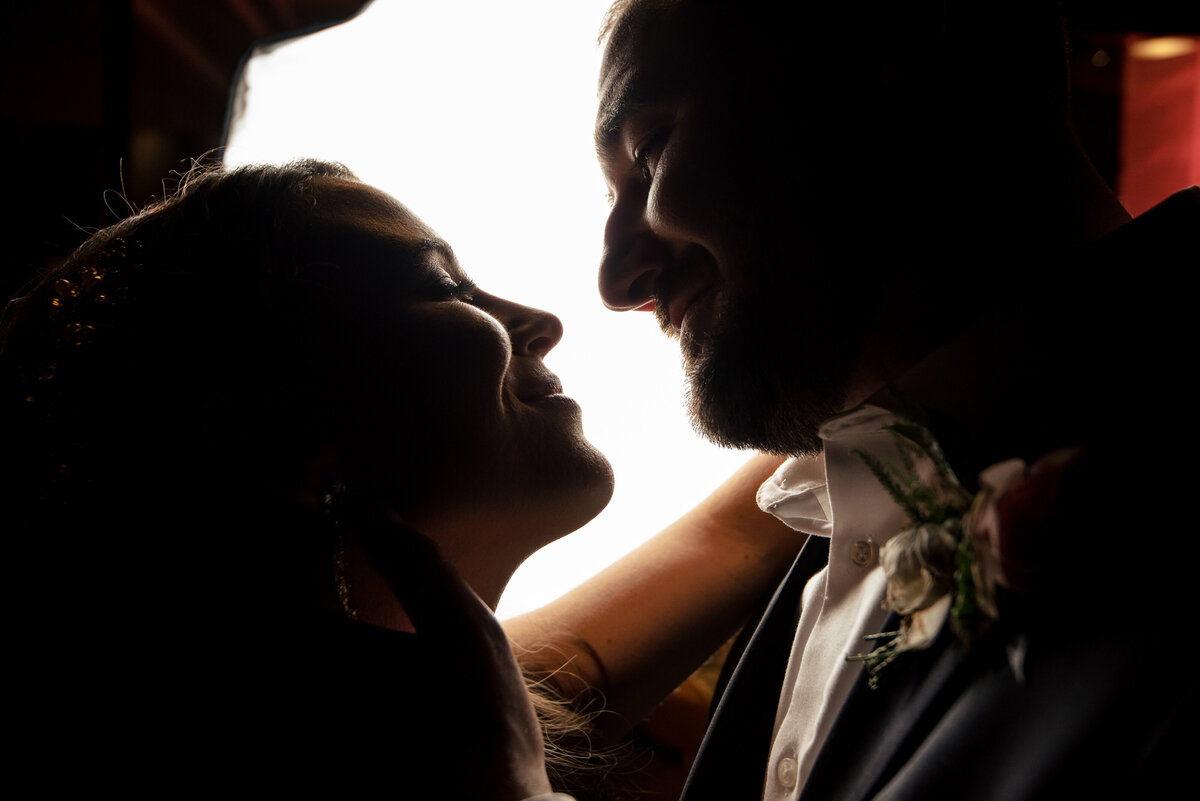 Upclose-nighttime-portrait-of-bride-and--groom-smiling-at-each-other-outside-Upstairs-Atlanta