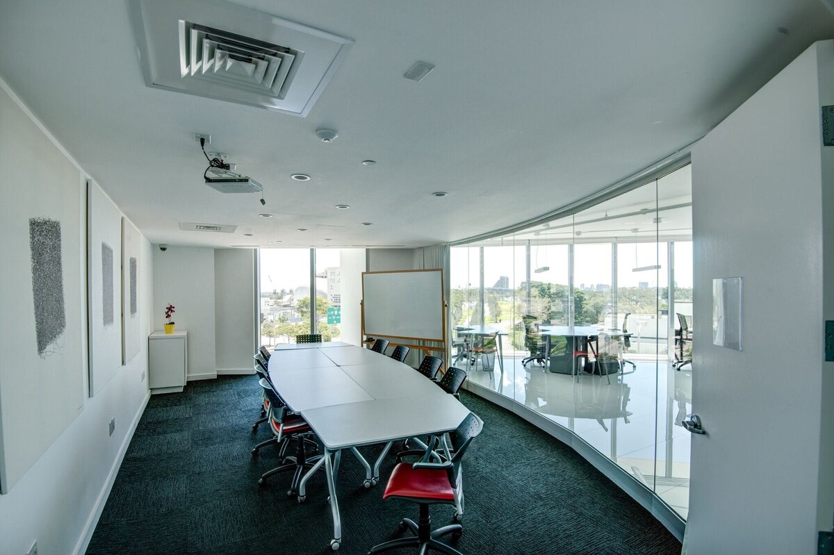 Large meeting table in white and glass conference room with presentation tools
