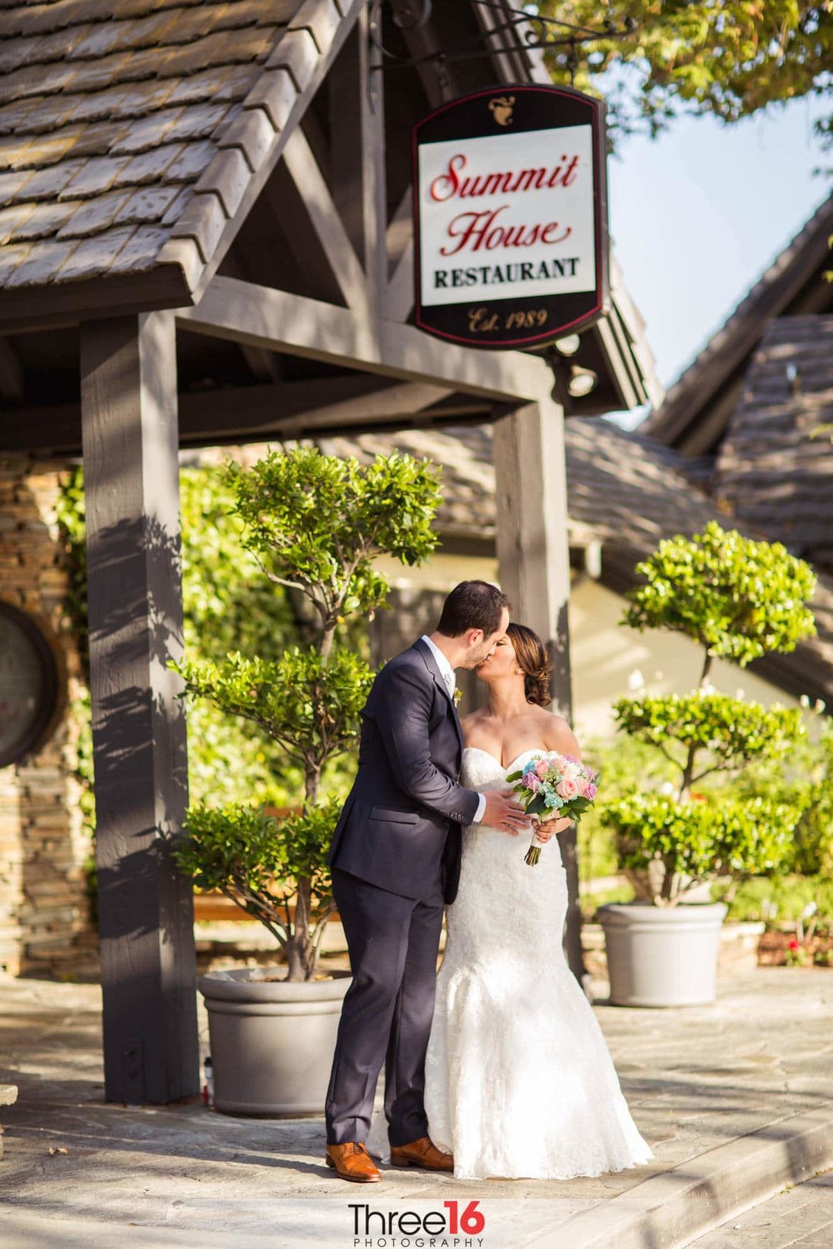 Bride and Groom share a kiss in front of the Summit House Restaurant