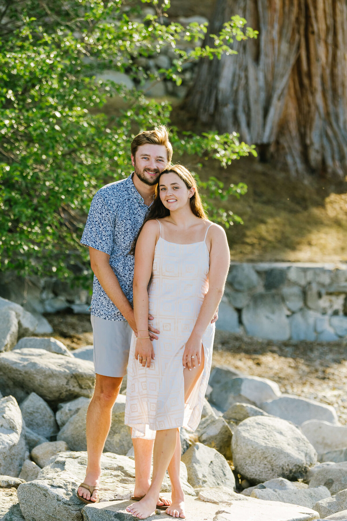 couple looking at camera after proposal at lake tahoe residence on the beach