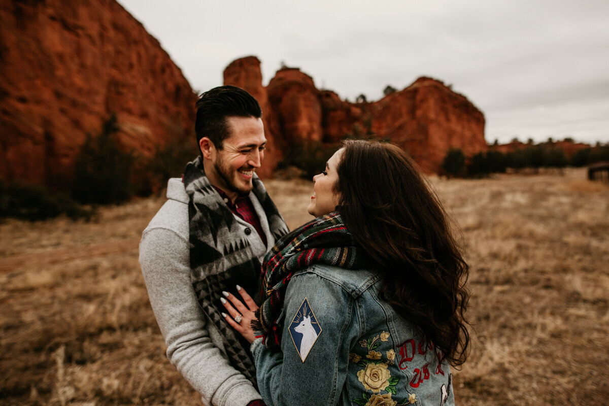 Engaged couple laughing in desert
