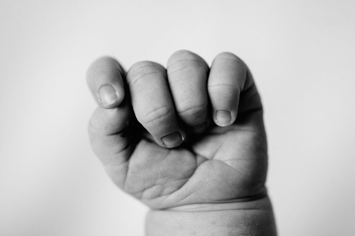 Newborn's fist in black and white