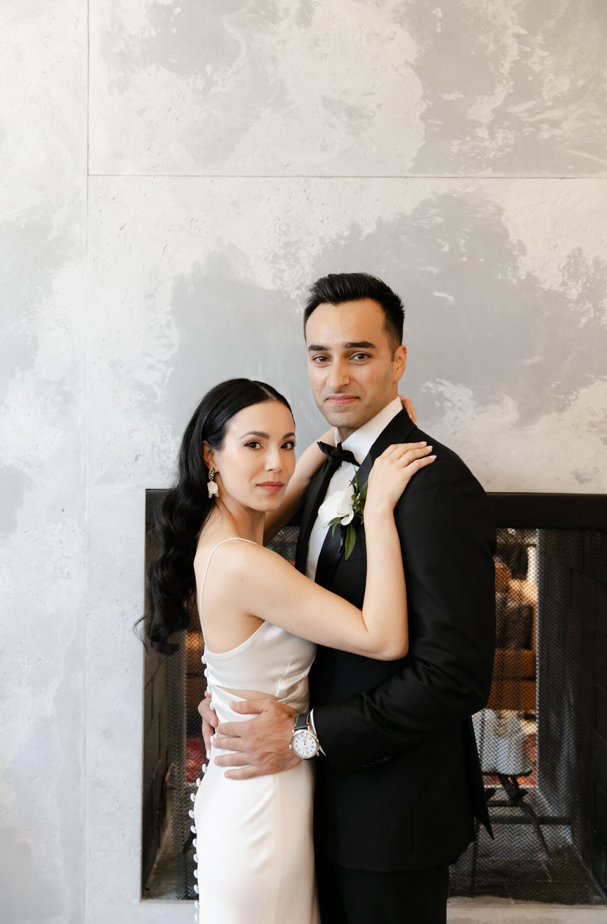 Sophisticated bride and groom softly smile at the camera at minimalist Chicago wedding.