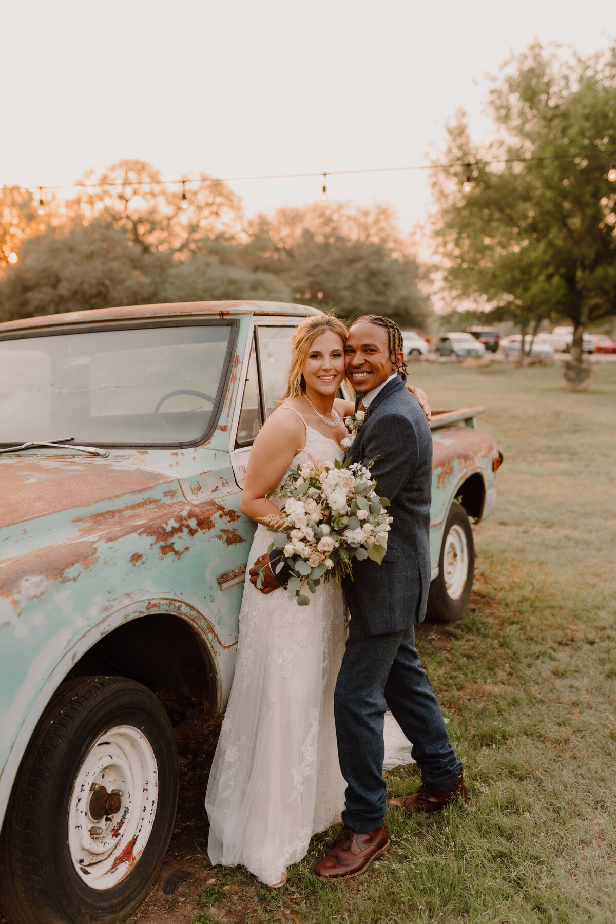 bride and groom pose with vintage truck