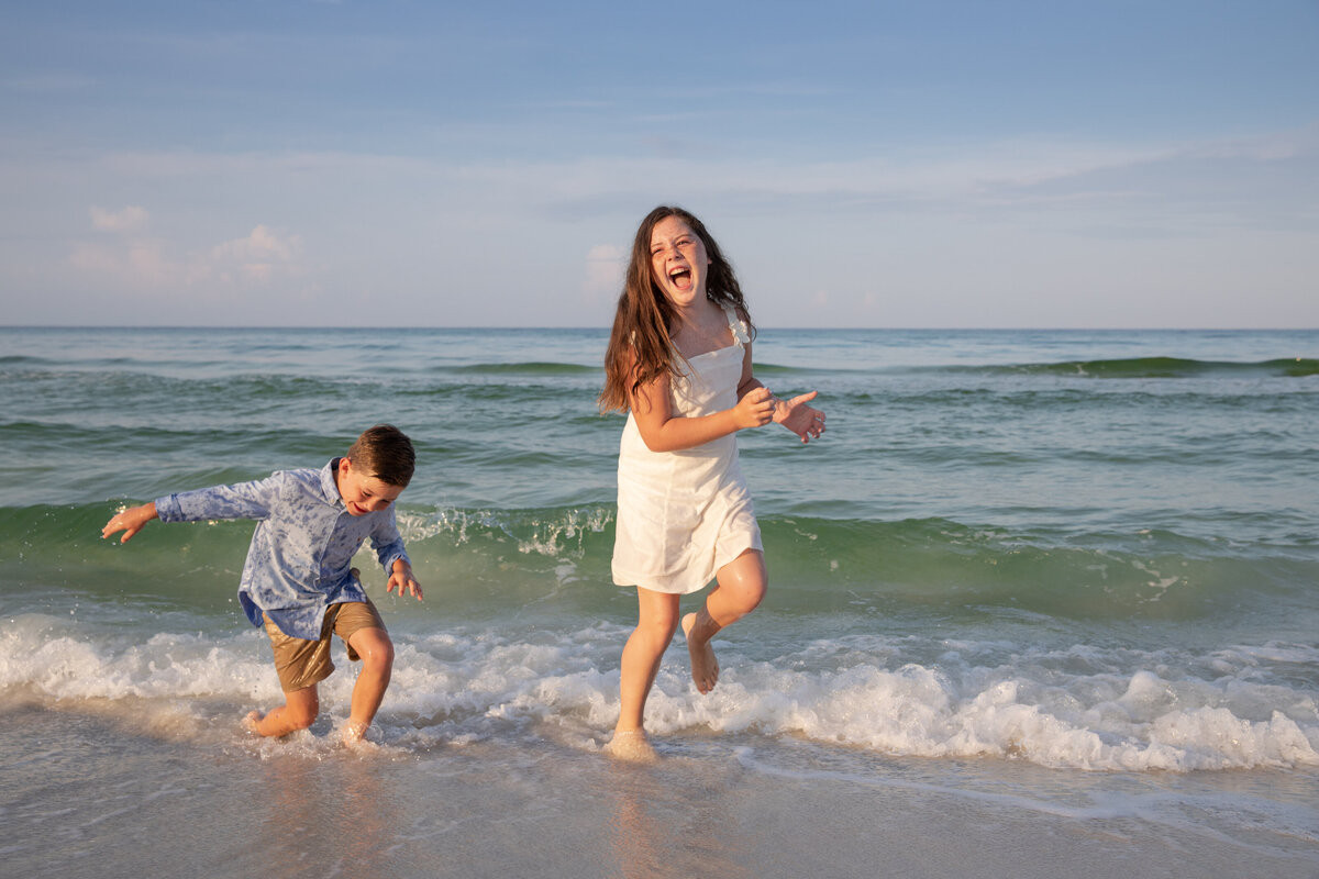 Two kids playing in the waves at the beach