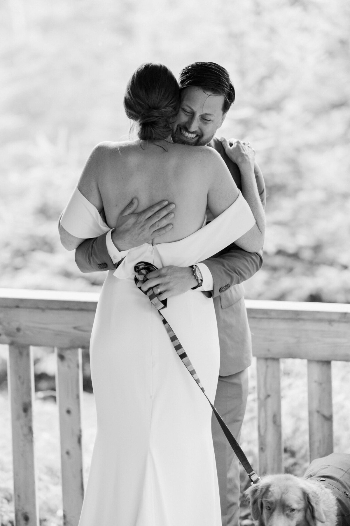 Bride hugging groom with dog on a lead at Oceanstone Resort Wedding in Nova Scotia