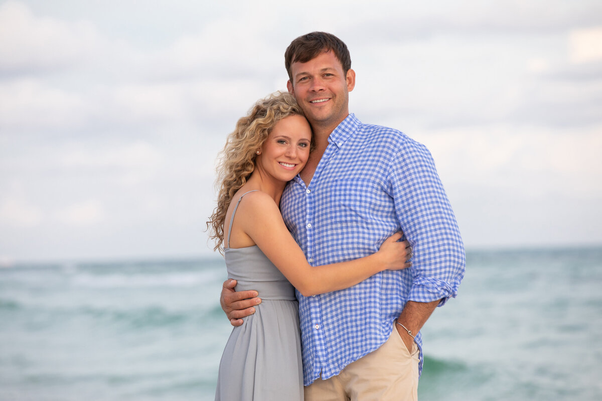 A couple hugging and smiling at the beach