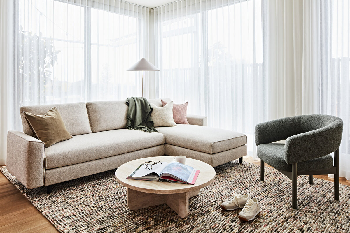 Soft neutral living room with boucle sofa, timber coffee table and layered textiles