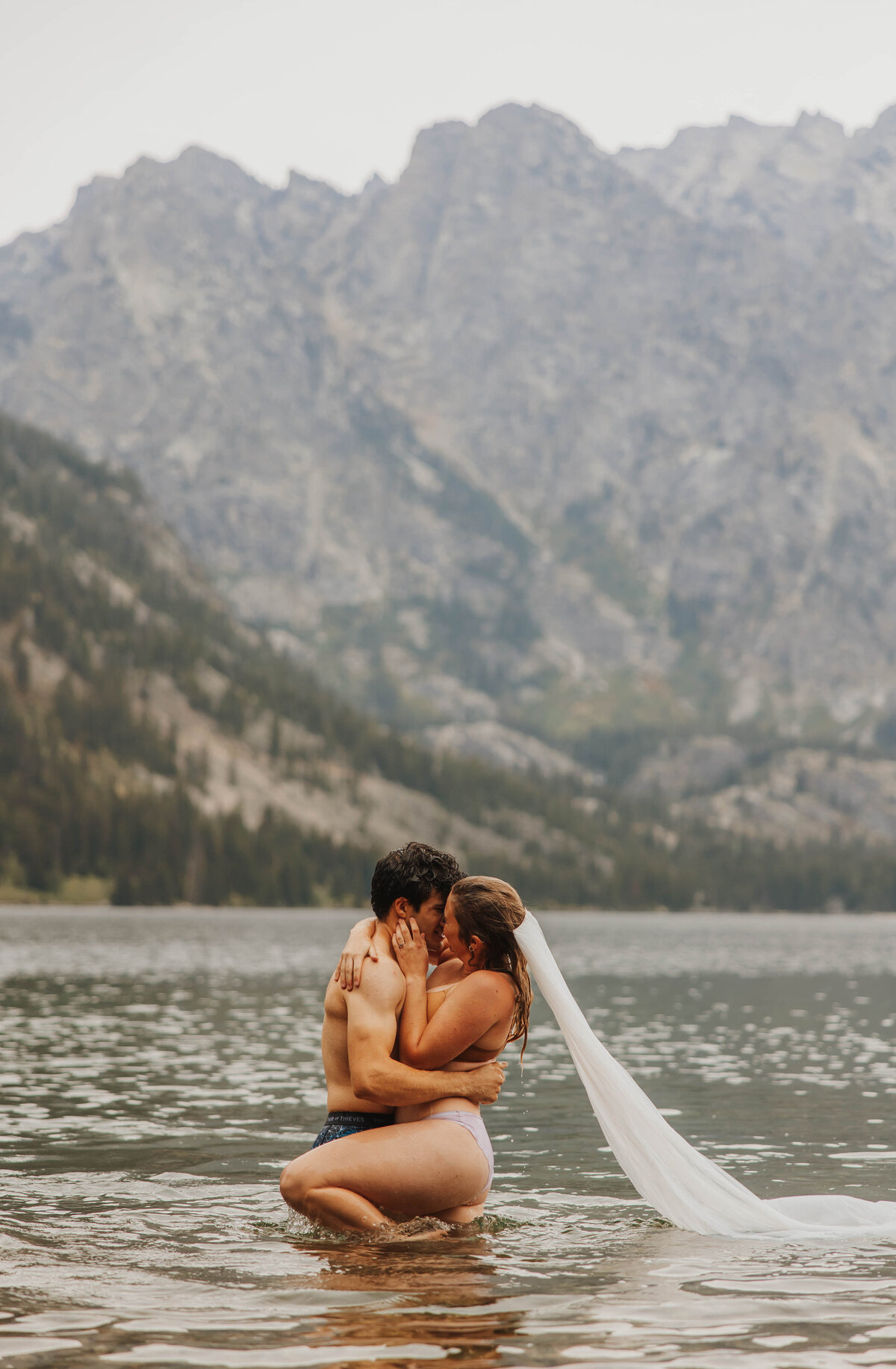 bride and groom posing in lake