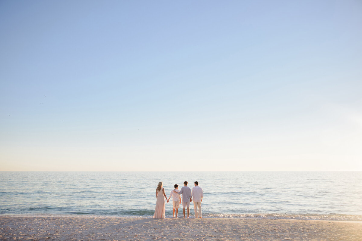 A family in the distance standing at the beach