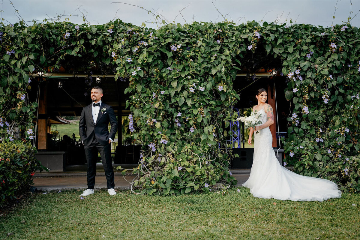 couple standing in front of greenery